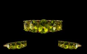 Peridot Graduated Band Ring, five oval cut peridots graduated slightly to either side of the