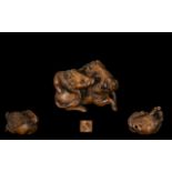 An Oriental Boxwood Netsuke in the form of two wild boars, signed to base.