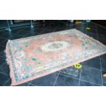 A Chinese Wool Rug 100% Wool. Peach ground with fringed edges, centre circular cream relief.