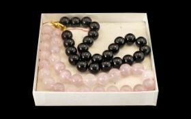 Two Heavy Jadeite Beaded Necklaces. Two beaded necklaces, one in black heavy jadeite with a gold