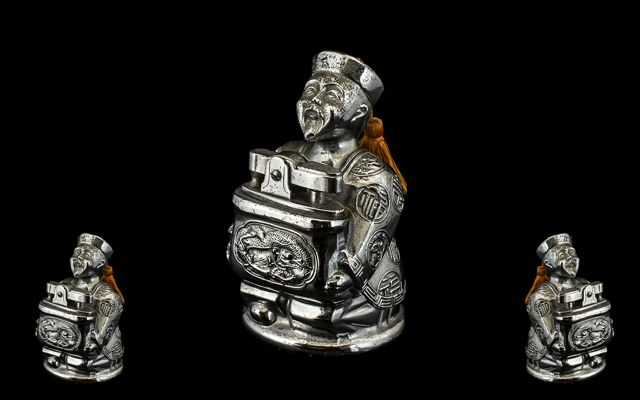 Unusual 1930s Chromed Metal Petrol Cigarette Lighter in the form of a seated Chinese Mandarin,