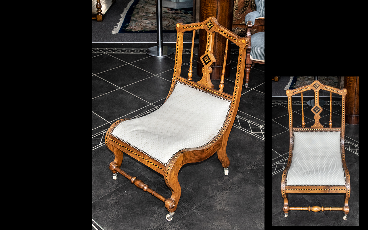 A Victorian Mahogany Nursing Chair of shaped scroll form with Ebony and Satinwood geometric inlay,