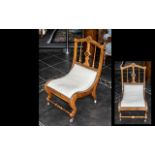 A Victorian Mahogany Nursing Chair of shaped scroll form with Ebony and Satinwood geometric inlay,