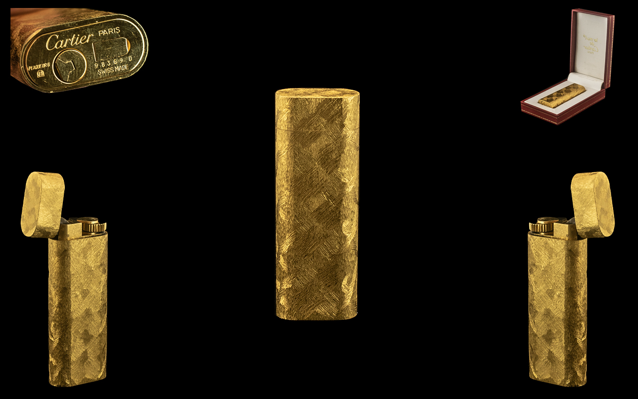 A Cartier Paris Cigarette Lighter of typical gold textured form.