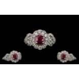 Ladies Attractive 18ct White Gold Ruby and Diamond Set Stylish Cluster Ring, the central ruby