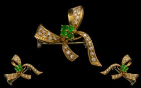 18ct Gold - Attractive Emerald and Diamond Set Bow Brooch. Marked 18ct - 750. The Round Faceted