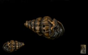 An Oriental Boxwood Netsuke in the form of frogs playing on a shell. Signed to underside. Please see