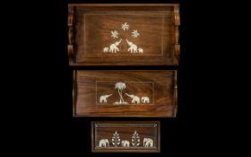 Three Small Hardwood Indian Trays inlaid depicting elephants. the largest measuring 18 by 10 inches.