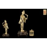 Japanese Meiji Period Sectional Ivory Figure of a man holding a bird and cage on a wood base.