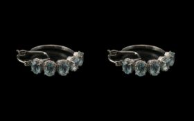 Sky Blue Topaz Hoop Earrings, each hoop having five oval cut sky blue topaz, set horizontally, in