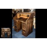 An Early 20th Century Oak Roll Top Pencil Desk of typical form with fitted interior,