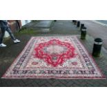 A Genuine Excellent Quality Persian Mashad Carpet/Rug decorated in a floral design on a rich red