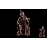 Antique Carved Chinese Cherry Wood Figure of an old man resting by the wayside, holding a rattan