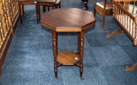 Occasional Table in Mahogany Veneer, raised on four turned legs, with lower shelf, on casters.