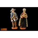 Pair of Pottery Figures of a Farmer and Wife, dressed in traditional garb, signed M.Decorg; 10