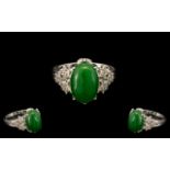 Green Jade and White Zircon Ring, an oval cut cabochon green jade of 7cts,