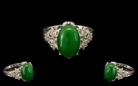 Green Jade and White Zircon Ring, an oval cut cabochon green jade of 7cts,