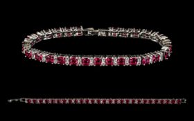 A Silver And Ruby Style Set Tennis Bracelet - Comprising 27 Ruby Style Stones,