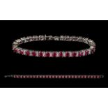A Silver And Ruby Style Set Tennis Bracelet - Comprising 27 Ruby Style Stones,