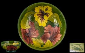 William Moorcroft Signed Tubelined Footed Bowl, 'Hibiscus' pattern, various colours on green ground.