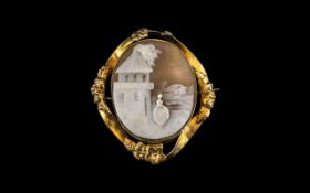 Antique Victorian Cameo Brooch depicting a lady outside a house, set in a gold metal floral frame.