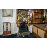 A Large Gilt Rococo Style Wall Mirror, of typical form. Measures 71" x 38".