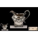 Early Victorian Ornate Embossed Silver Milk Jug of small proportions with swan necked handle gilt