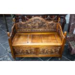 A Carved Stained Pine Monk's Bench, with a lift up seat with carved panels below.