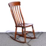 A stained wood lath back kitchen chair, solid seat, adapted as a rocker, height 98cm.