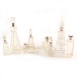 Eight silver-topped glass perfume / liqueur bottles.