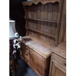 A stripped pine Lincolnshire dresser base, fitted with three drawers and a door, width 123cm, a
