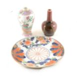 An Arita style porcelain plate, a Chinese famille rose vase, and a high fired vase