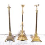 A modern brass Corinthian column standard lamp, and two brass oil lamp bases
