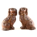 A pair of treacle glazed stoneware models of seated Spaniels, North Midlands, mid-19th Century