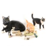 A collection of cat-related figurines, collectors plates, and decorative items
