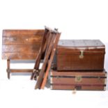 A stained oak folding garden table, two luggafe stands, and two old trunks