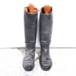 A pair of leather riding boots with wooden trees.