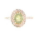 A green stone and diamond oval cluster ring.