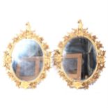 Pair of oval gilt composition framed wall mirrors,