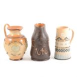 Three Doulton Lambeth stoneware jugs, including a Slater's Jack jug for King Charles' coronation