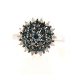 A circular blue and white diamond cluster ring.