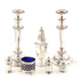 A silver caster, three piece condiment set, salt and pair of plated candlesticks.