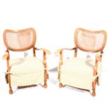 A pair of beech framed bergere back low chairs.
