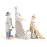 A Lladro figure of a clown and violin, and two Nao figures.