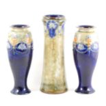 A pair of Doulton stoneware vases and similar single cylindrical vase.