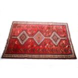 A Persian carpet with three lozenge medallions, strawberry field