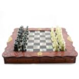 Modern Chinese chessboard, porcelain chequerboard with simulated carved figural chess pieces.