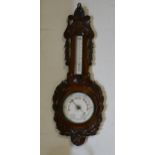 An Edwardian carved oak aneroid barometer,