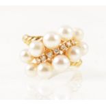 Mikimoto - an 18 carat yellow gold dress ring set with seven graduated small diamond and pearls.