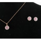 A pink sapphire and diamond pendant and matching earstuds.